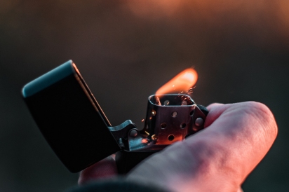 An image of a person lighting a fire with a lighter