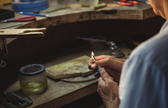 An Image of a Craftswoman using a lighter flame in workshop Unlocking Creative Potential