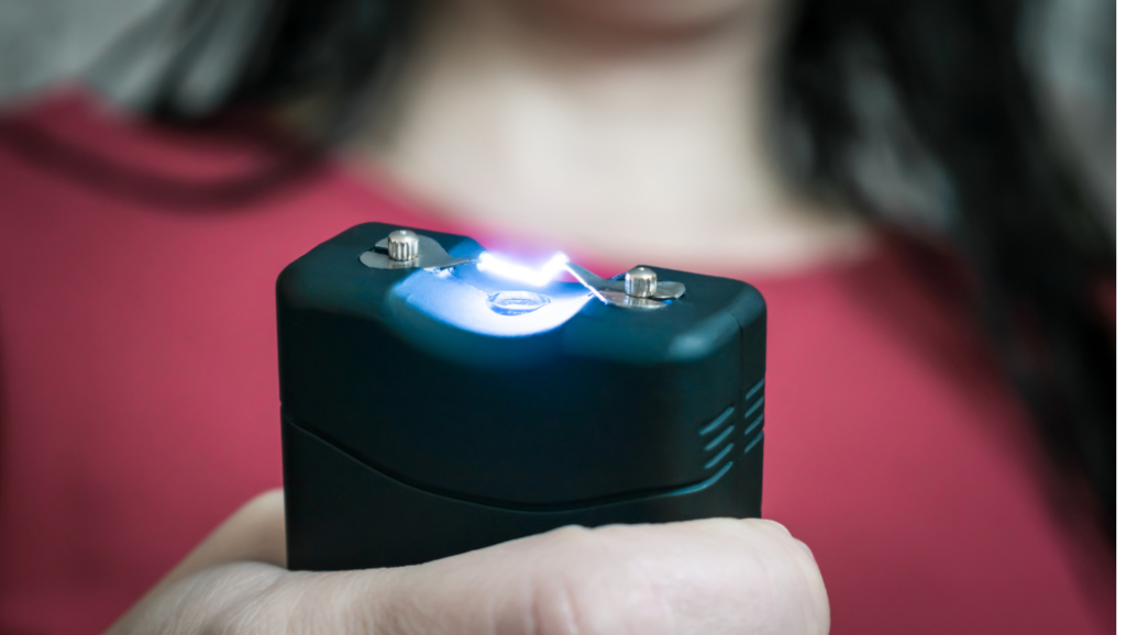 The stun gun in the hands is a close-up. Selective focus