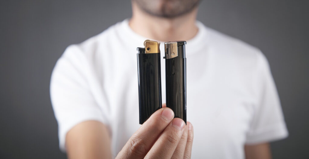 An image of a man holding traditional bic lighters
