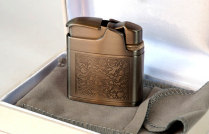 An Image of a Metal gold Lighter with Engravings