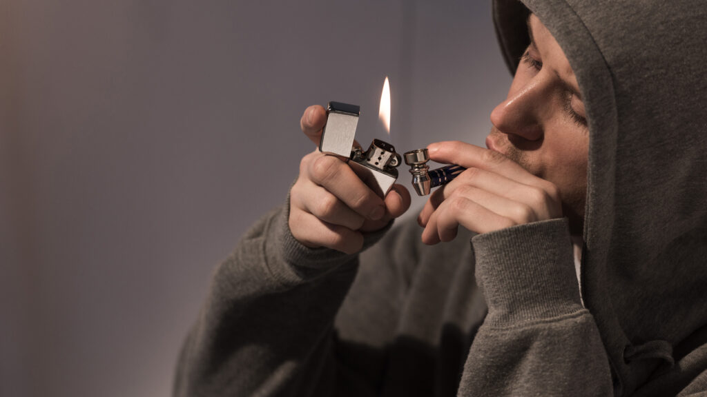 an image of man lighting  a pipe with one of the best pipe lighters
