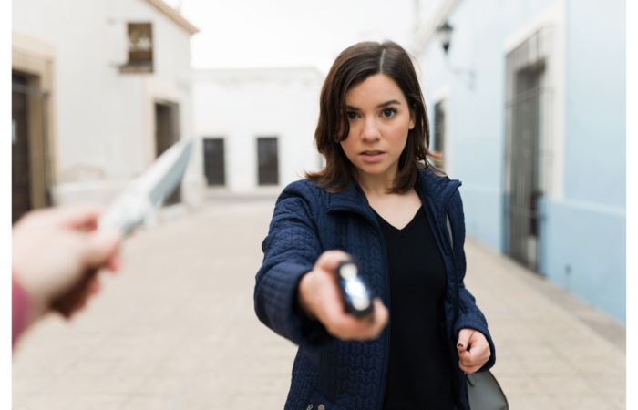 A woman holding a mini stun gun