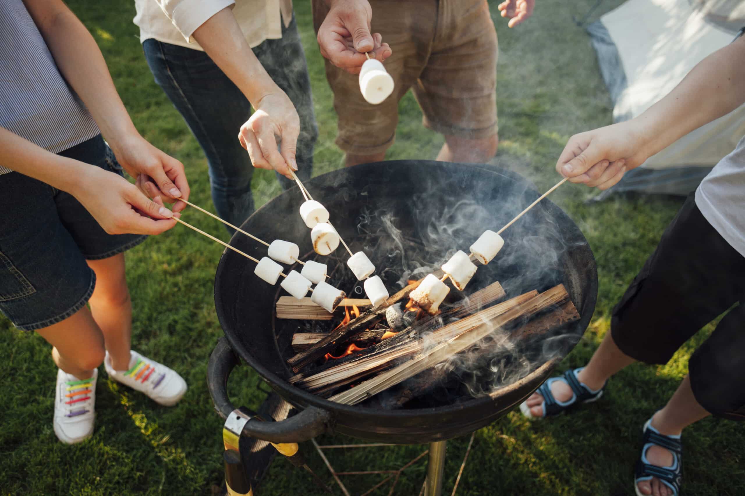 elevated-view-hands-roasting-marshmallow-barbecue-fire lightened using a grill lighter